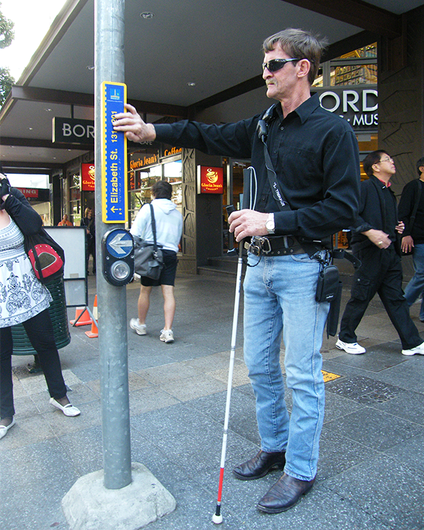 A vision-impaired gentleman demonstrates Cairns' new wayfinding signage