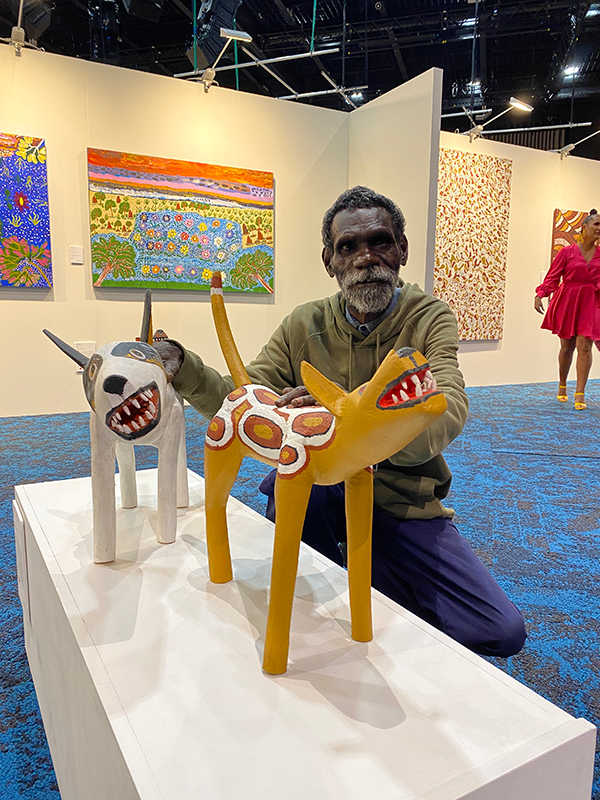 Apalech man Lex Namponan with two camp dogs called ku’ in Wik Mungkan. The yellow ku’ is his and the white one was carved by his brother Leigh
