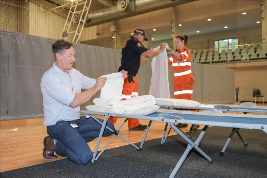 City of Logan Mayor Darren Power helping prepare beds at the
Logan Metro Sports & Events Centre in Crestmead